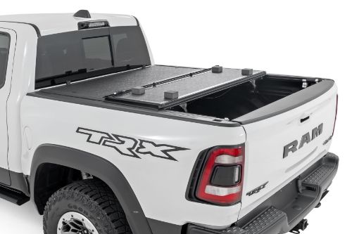 Flush, low-profile design with stylish matte black finish frame and aluminum panels. Tri-Fold Design allows quick access to cargo. Corrosion resistant black powder coated aluminum frame. Secure track and rail mounting system with drain tubes included. Nylon straps secure the cover in the 2/3 open position. Drive with the cover in the 2/3 open or closed position. Auto latching design secures on closure. Single cable pull for easy latch release and access. No drill easy install and removal - all tools included. Nylon safety straps included. 5 Year Warranty.